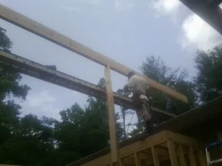 Carpenter setting a ridge beam over a new addition frame — Ice Dam Removal by Roofing Brothers in Annawan