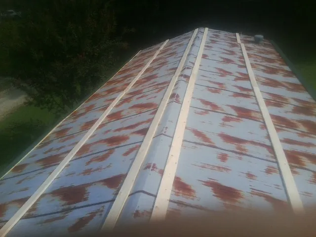 Rusted metal roof panels with new wood purlins before replacement — Storm Damage Roof Repair in Annawan by Roofing Brothers