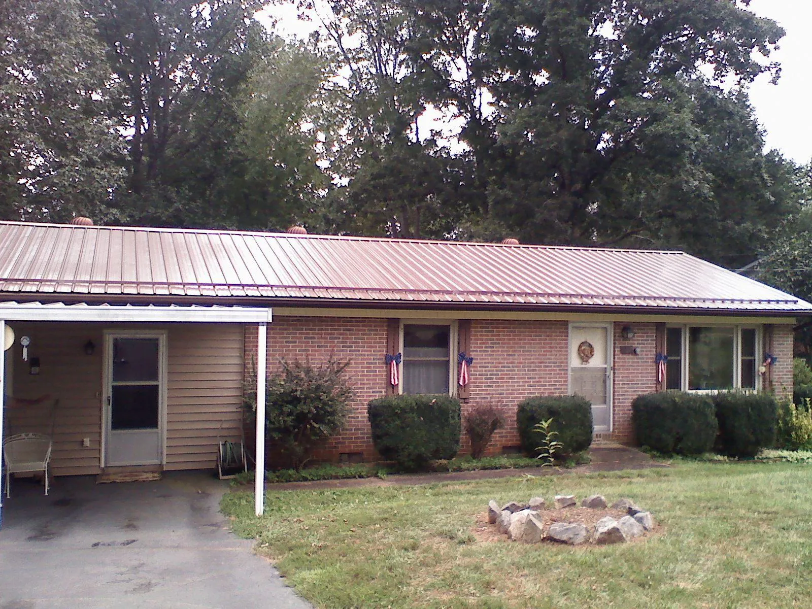 Bronze metal roof and carport on a brick ranch home — Roof Repair work by our crew in Annawan